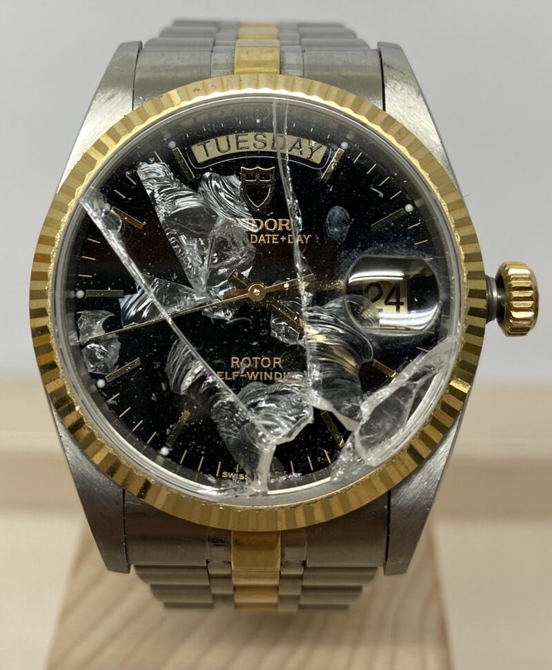 Tudor watch before repair, showing the damaged crystal